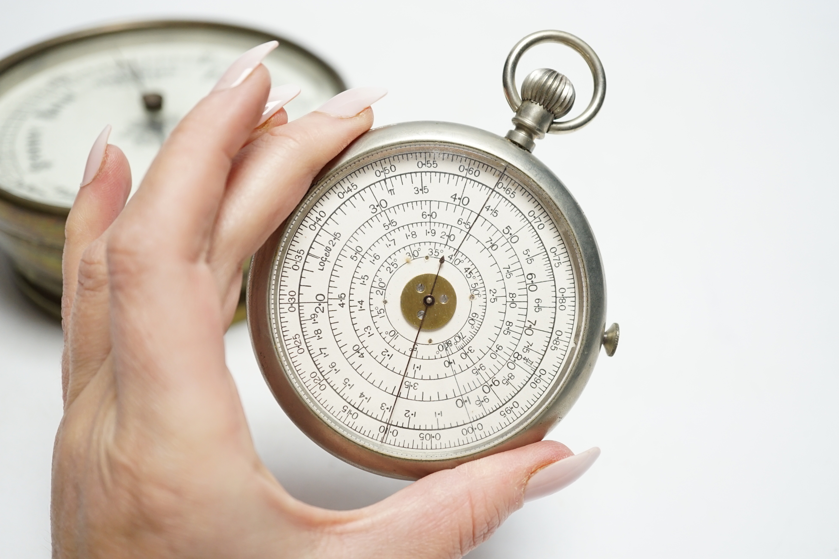 An aneroid barometer and a pocket calculator, calculator 11cm high